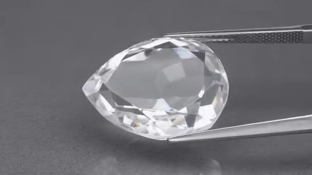 Природный белый кварцевый камень на поворотном столе в пинцетах — стоковое видео