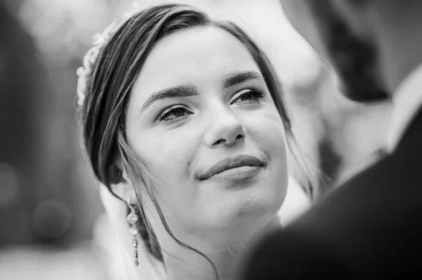 La novia y el novio están caminando en el parque en el verano, abrazándose. Los recién casados están caminando en el parque. Árboles en el fondo —  Fotos de Stock