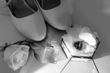 Gelin aksesuarları. Altın alyanslar, damadın yaka çiçekleri, gelin için düğün davetiyesi.