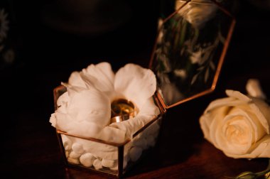 Düğün aksesuarları. Altın alyanslar, damatlar yaka çiçeği