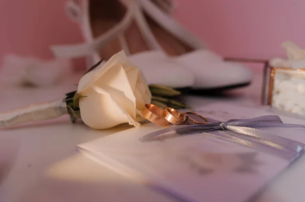 Gelin aksesuarları. Altın alyanslar, damadın yaka çiçekleri, gelin için düğün davetiyesi. — Stok fotoğraf
