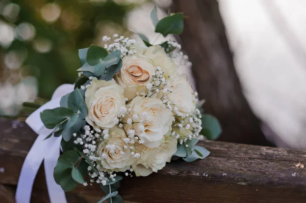 Un par de anillos de oro en un ramo de rosas blancas —  Fotos de Stock