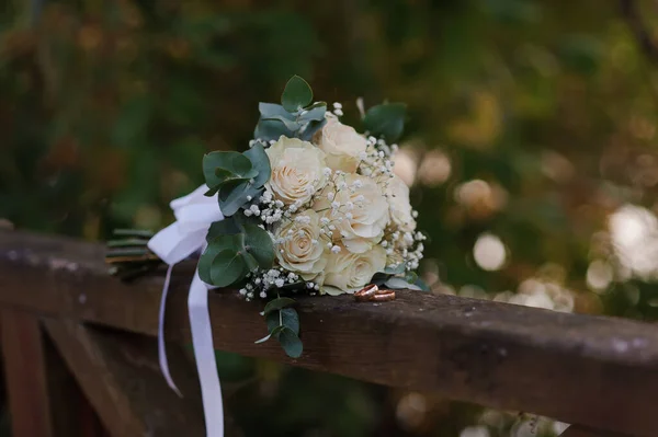 Пара золотых колец на букете белых роз — стоковое фото