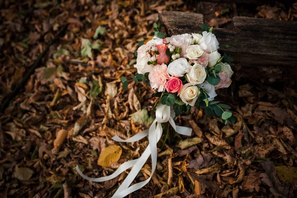 Золотые обручальные кольца, красивый свадебный букет цветов — стоковое фото