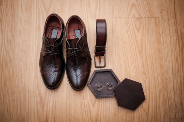 Deri erkek ayakkabıları, ahşap bir kutuda bir çift altın alyans. Damat aksesuarları