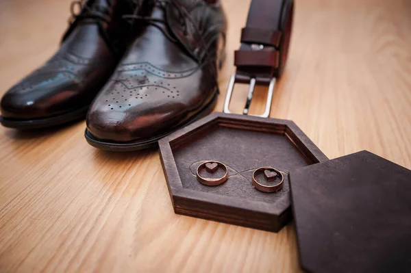 Kožené pánské boty, zlaté snubní prsteny v dřevěné krabici. Ženichovy doplňky — Stock fotografie