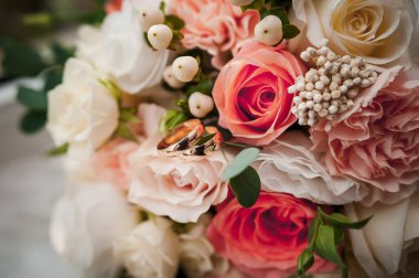 Güzel bir gelin buketi, bir çift altın alyans.