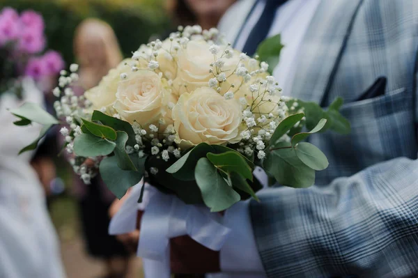 Wedding bouquet in the hands of the groom. Beautiful bridal bouquet in the hands of a man — Stock Photo, Image
