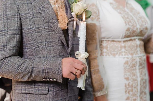 花嫁と新郎は 教会での儀式の間に輝くろうそくを保持します 教会にろうそくを持って新婚旅行の手 教会の宗教的詳細 — ストック写真