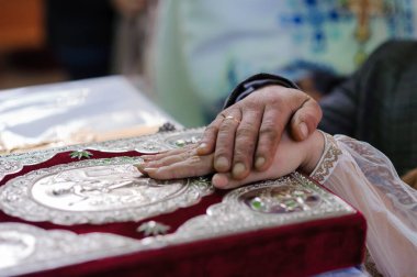 Kilisede düğün töreni. Gelinin ve damadın elleri