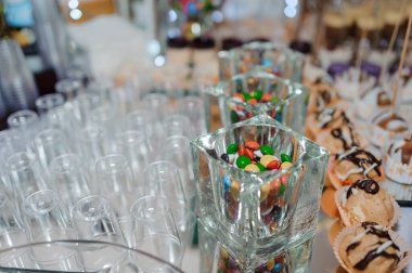 Düğün büfesinde fincanlarda tatlı kekler. Şeker çubuğu