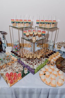 Düğün büfesinde fincanlarda tatlı kekler. Şeker çubuğu