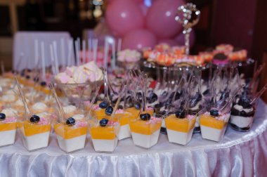 Düğün büfesinde fincanlarda tatlı kekler. Şeker çubuğu