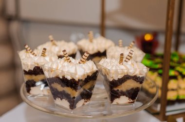 Düğün büfesinde fincanlarda tatlı kekler. Şeker çubuğu