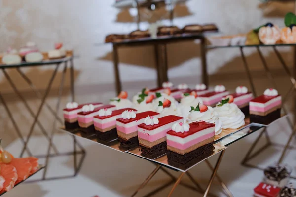 Sweet cakes at a wedding banquet. Catering, sweet festive buffet