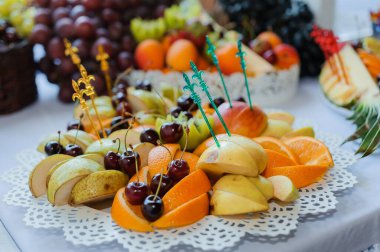 Düğün ziyafetinde meyve dilimleme. Karpuz, üzüm, çilek, portakal, erik, armut, dinya şeftalili kivi ananas, elma.