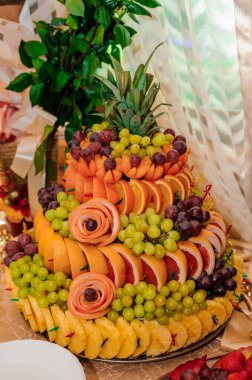 Düğün ziyafetinde meyve dilimleme. Karpuz, üzüm, çilek, portakal, erik, armut, dinya şeftalili kivi ananas, elma.