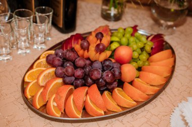 Düğün ziyafetinde meyve dilimleme. Karpuz, üzüm, çilek, portakal, erik, armut, dinya şeftalili kivi ananas, elma.