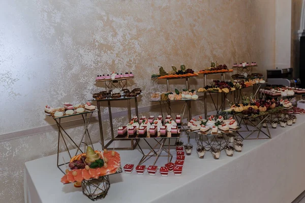 Pasteles dulces en un banquete de bodas. Catering, buffet festivo dulce. Candy bar — Foto de Stock