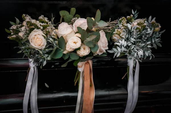 Prachtig bruidsboeket op de piano. Bruiden boeket van witte bloemen op een zwarte achtergrond — Stockfoto