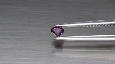 Doğal pembe safir taşı cımbızda.