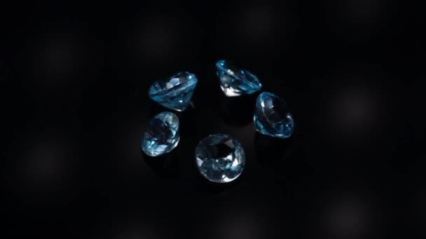 Natural blue topaz gemstones on the dark background turning table — Stock Video