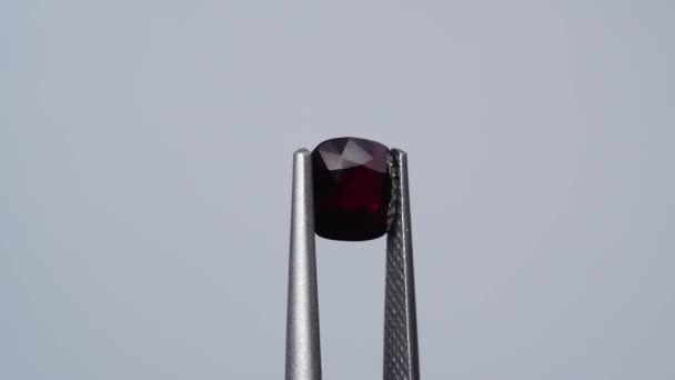 Piedra de gema de espinela cortada cusgion rojo oscuro natural en la mesa giratoria — Vídeos de Stock