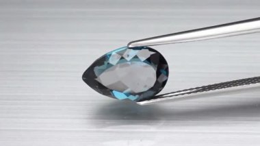 Doğal Londra mavisi topaz armudu cımbızda kesilmiş.