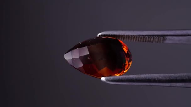 Imperial champagne yellow topaz pear cut in the turning tweezers — Stock Video