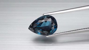 Doğal Londra mavisi topaz armudu cımbızda kesilmiş.