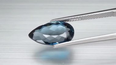 Doğal Londra mavisi topaz armudu cımbızda kesilmiş.