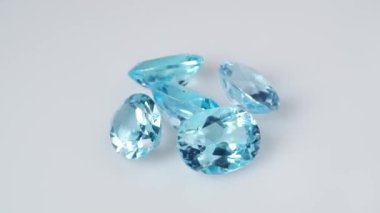 Beyaz arkaplan masa üzerinde doğal mavi topaz değerli taşlar
