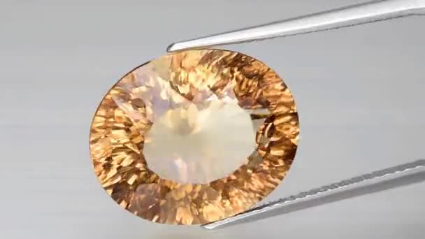 Imperial champagne yellow topaz oval cut in the turning tweezers — Stock Video