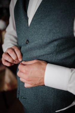 Adam ceketine düğme takıyor.