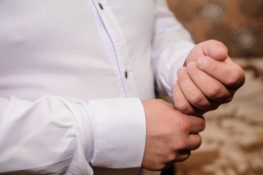 Erkekler gömleklerine kol düğmesi takıyor.