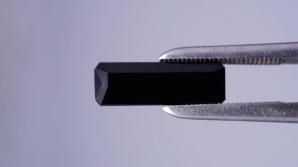 Black tourmaline scherl rough specimen in the tweezers — Stock Video