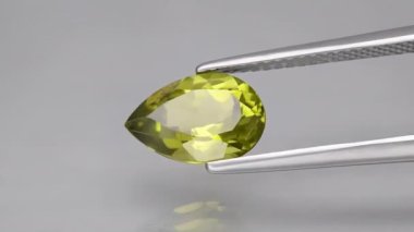 Arka plandaki cımbızda doğal peridot taşı var.