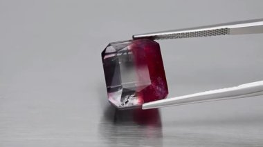 Doğal çift renkli turmalin sekizgeni cımbızda kesilmiş.