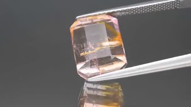Φυσικό δίχρωμο πολυχρωματικό οκτάγωνο τουρμαλίνης κομμένο στα τσιμπιδάκια — Αρχείο Βίντεο