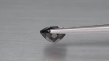 Doğal olarak oval kesim, cımbızda kahverengi turmalin.