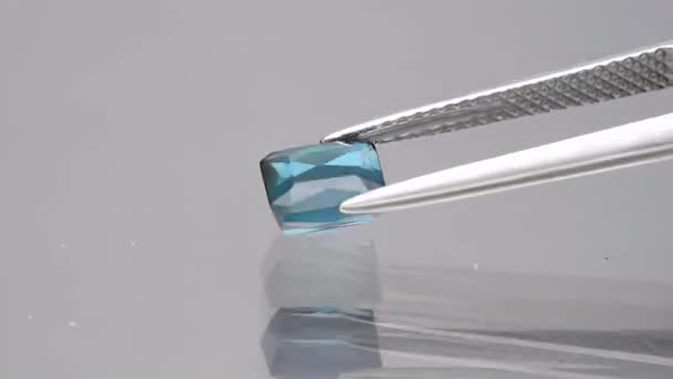 Natural blue tourmaline indicolite baguette in the tweezers — Stock Video