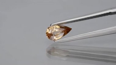 Doğal mücevher sarısı zirkon armudu cımbızda kesilmiş.