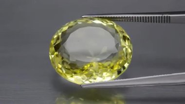 Doğal sarı sitrin oval kesikler, çevirme masasındaki cımbızda.