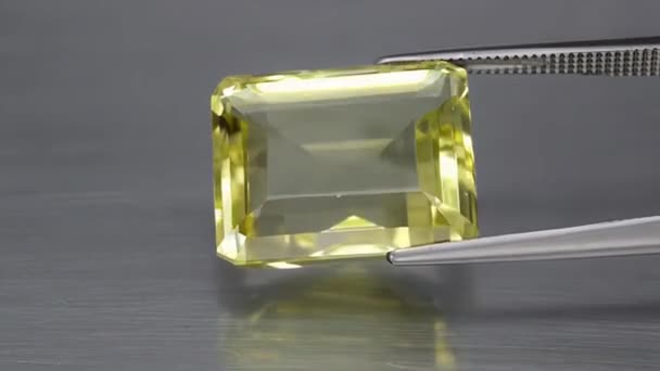 Natural yellow citrine octagon faceted cut in the tweezer on the turning table — Stock Video