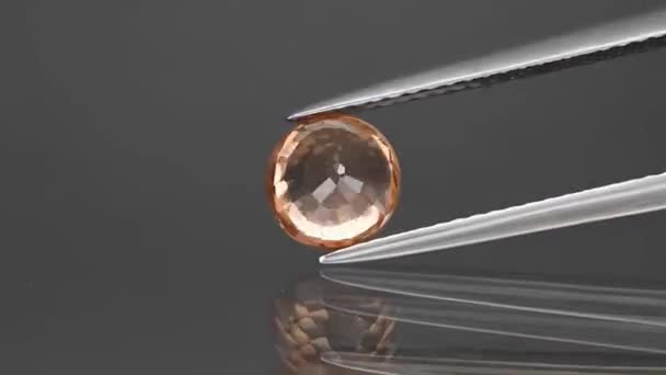 Natural gemstone yelow zircon round cut in the tweezers — Stock Video