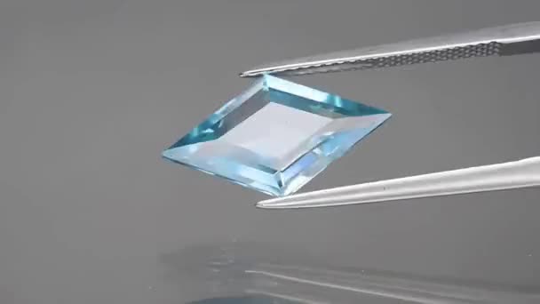 Natural gemstone blue zircon lozenge cut in the tweezers — ストック動画