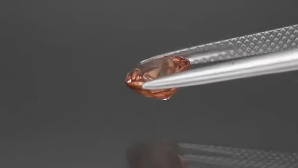 Natural gemstone yelow zircon round cut in the tweezers — Stock Video