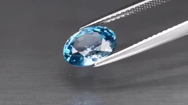 Pedra preciosa natural azul zircão corte oval nas pinças — Vídeo de Stock