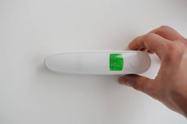 Vücut ısısını ölçmek için arka planda temas olmayan termometre. Termometre hazır.