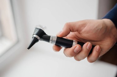Otoskop bir otolaringolojistin elinde. Kulak ve orta kulağı incelemek için araç